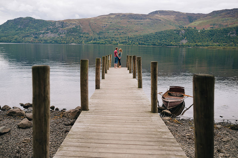 couple standing on the end of a pier