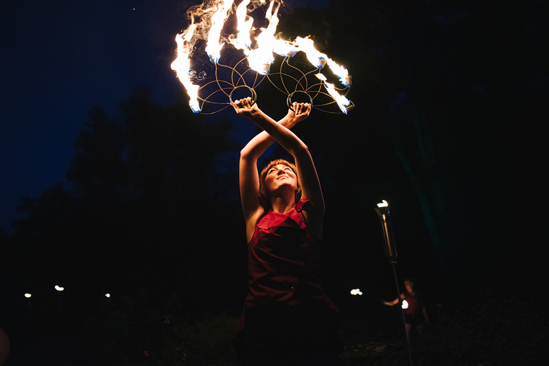 fire dancer holding burning flames above her head