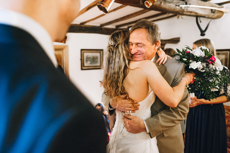 father hugs bride during lake district wedding in keswick farm barn