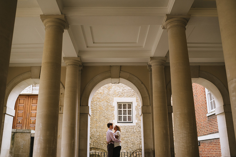 couple hug in entranceway underneath archway and pillars