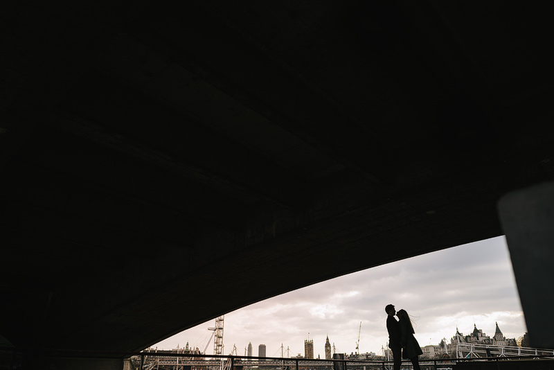 silhouette of couple underneath huge london bridge