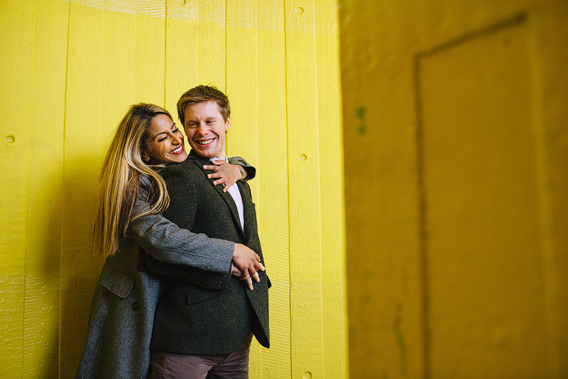 couple hugging in front of yellow background
