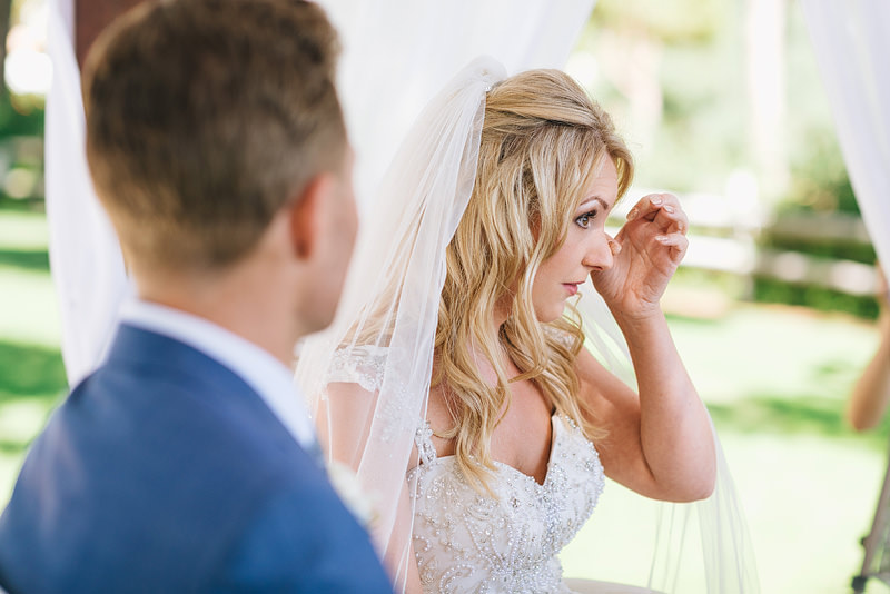 The bride wipes a tear away from her eye during the readings