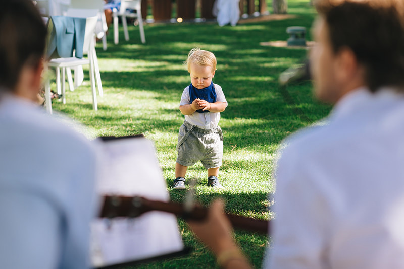 A toddler wanders over to listen to the musicians