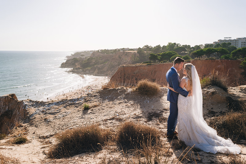Incredible wedding photo of a couple on a clifftop overlooking a