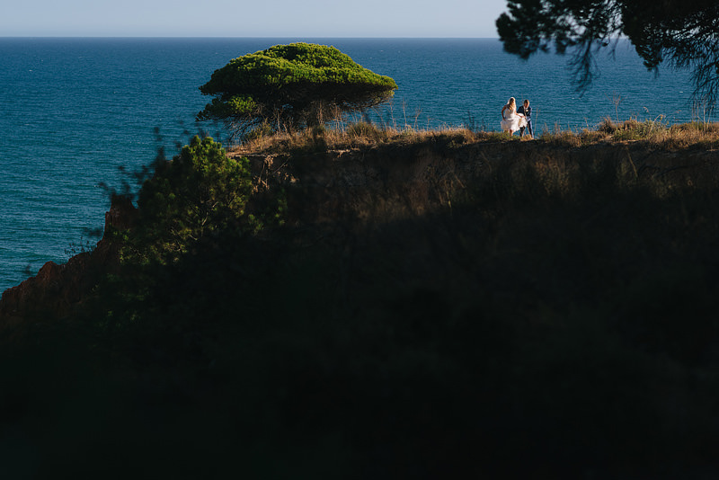 adventurous bride and groom walking along a clifftop