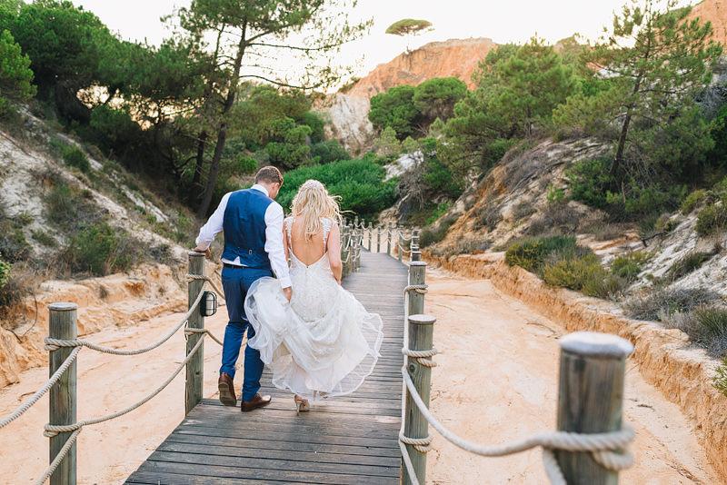 newlyweds walk through the valley down to the beach