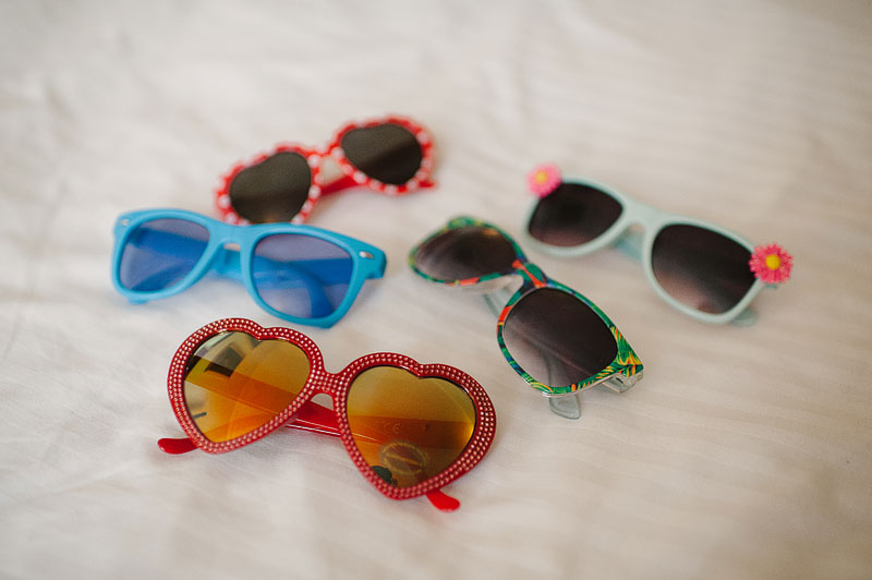 Vintage wedding sunglasses laid out on a bed in the bridal suite