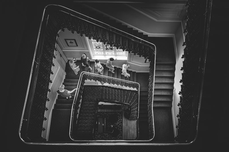 Bride and Bridesmaids walk down magnificent staircase at the millennium baileys hotel, london.