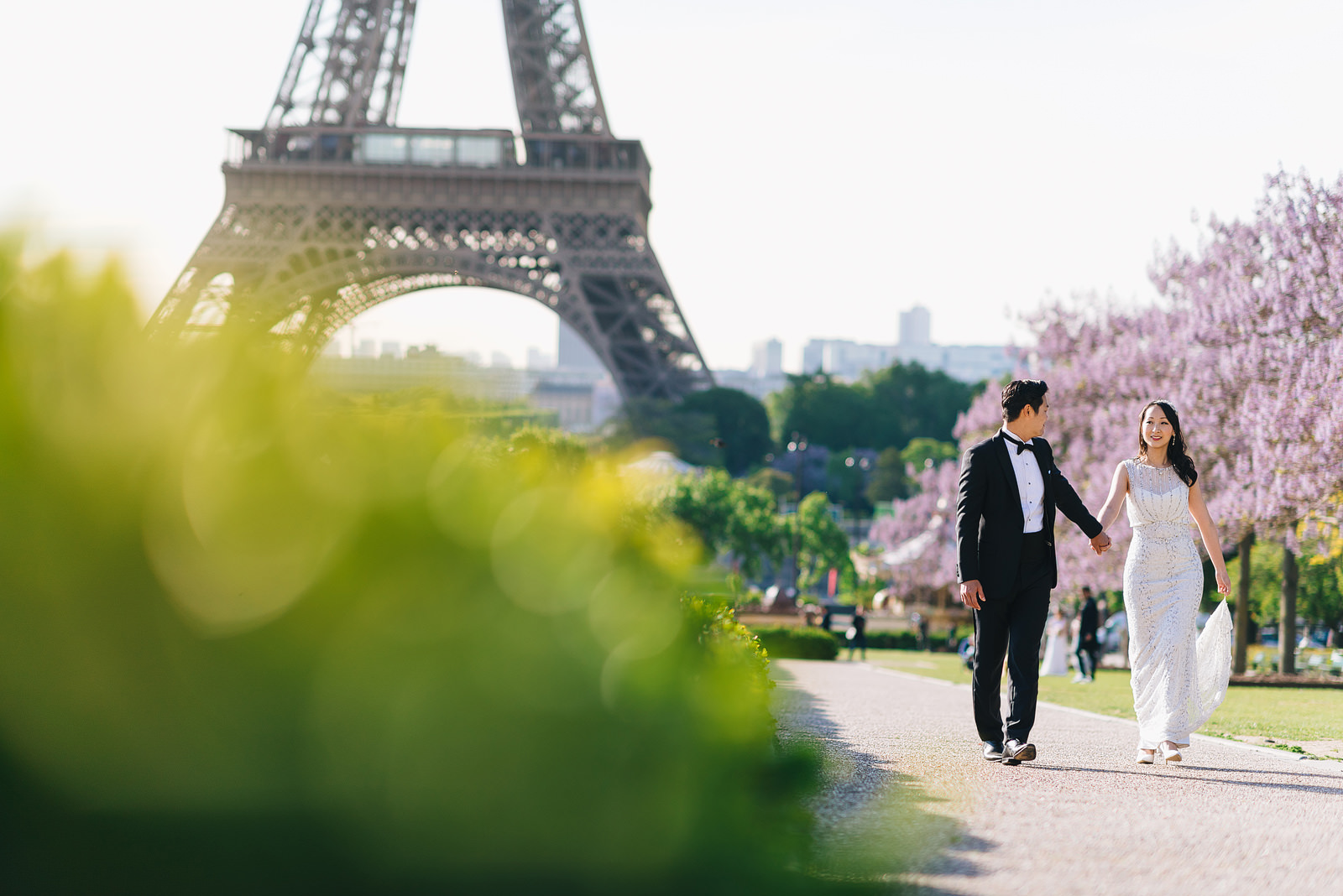 Bride and groom walking past the Eiffel Tower on a pre-wedding shoot in Paris