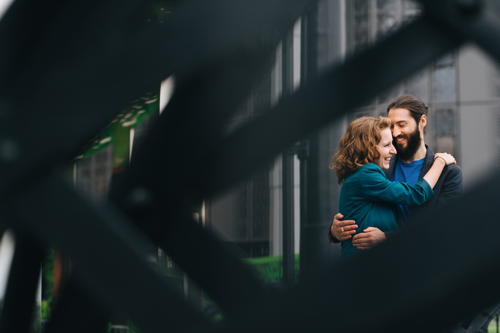 couple embrace framed by steel structure