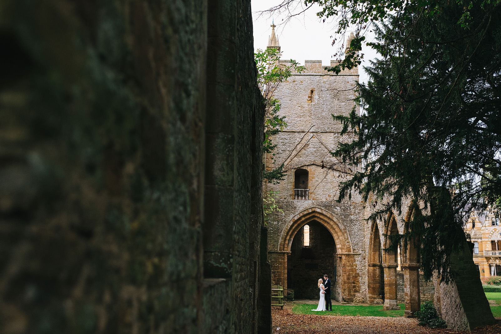 Bride and Groom cuddle outside the old Norman Chapel